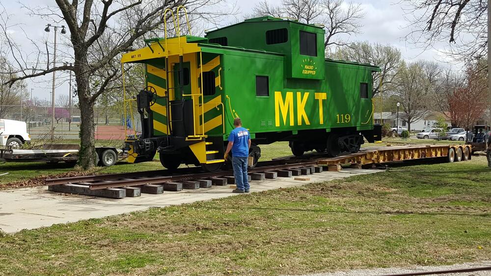 A worker looking over the green caboose