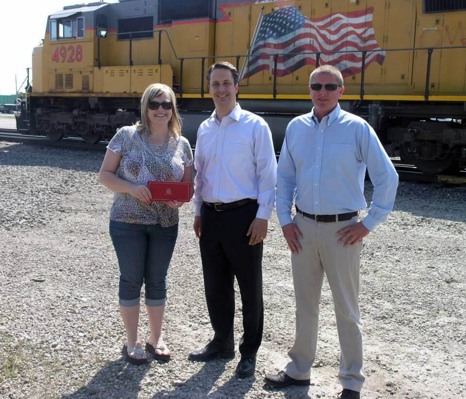 3 citizens standing next to the yellow Union Pacific Columbine train